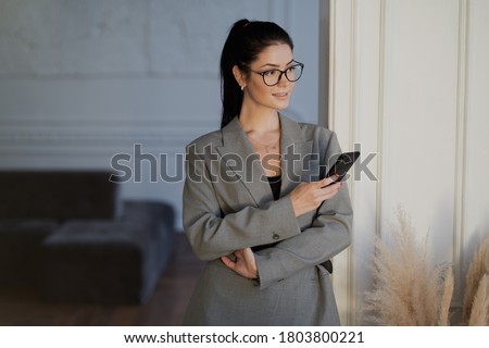 a young businesswoman is talking on a mobile phone. portrait of a brunette girl glasses. background white color