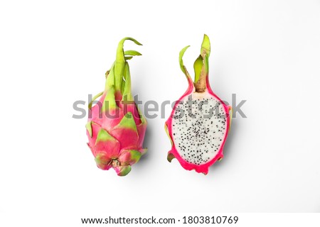Delicious cut and whole dragon fruits (pitahaya) on white background, top view