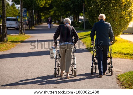 Senior couple walking on the steer with rollators