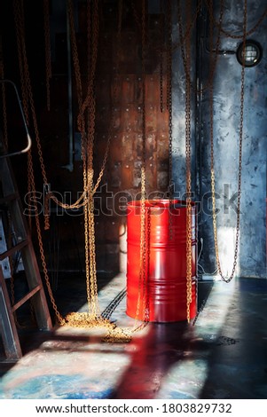 Interior of factory industrial shop with chains and a red barrel is illuminated by sunlight from window. Luxury background for presentation, design, poster with copyright space for text or logo