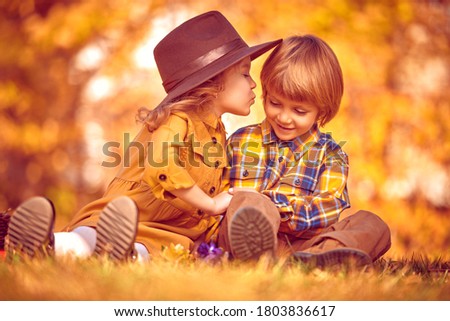 Funny romantic kids boy and girl spending time together in a beautiful autumn park. Children's fashion. Retro style.