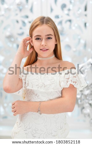 Close up portrait of teenage girl in white dress posing on holiday