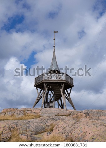 Viewing tower on a hill with a cloudy sky background