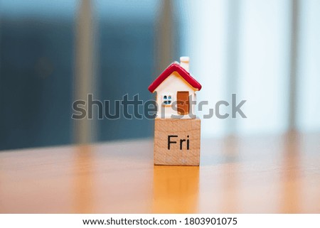 Miniature house and Friday wooden block using as family and property real estate concept