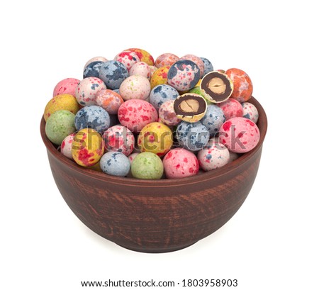 chocolate peanuts with colored glaze isolated on white background, in a plate
