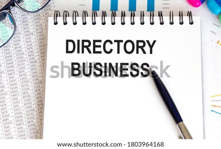 Notepad with text DIRECTORY BUSINESS on a white background, near calculator, tablet and pen. Business concept.