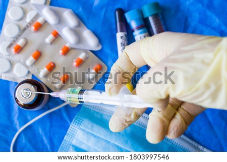 Vaccine in the needle, hand with glove holding needle, drugs and ampule, corona virus vaccine