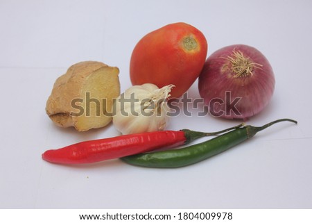 Onion, Half Cut Ginger, Red and Green Chilies and Two Bulbs of Garlic are Set on a White Background, Selective Focus
