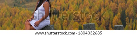 Banner of pregnant young woman with beautiful autumn colors in the background