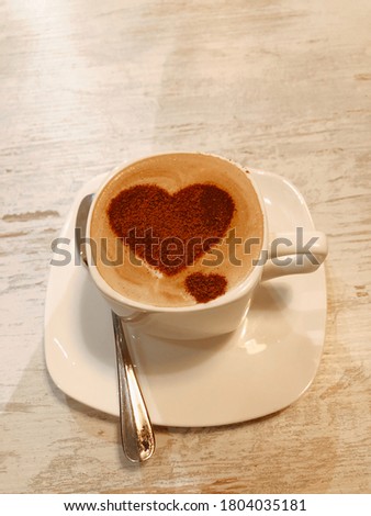 cup of coffee with milk and cinnamon heart