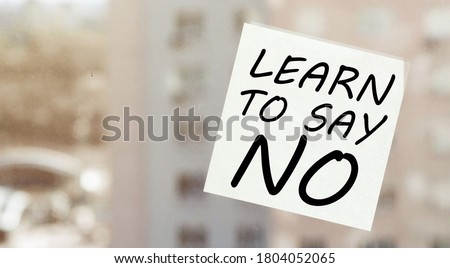 white paper with text Learn To Say No on the window