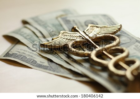 Expensive healthcare concept, caduceus on US money Royalty-Free Stock Photo #180406142