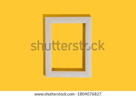 Frame for photo or painting on bright yellow background. Mockup. Place to insert text, images. Top view. Flat lay.
