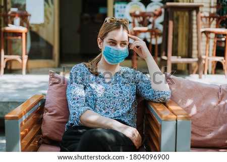 Young worried woman with mask outdoors thinking, Depressed Woman fired from job
