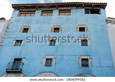 Tall pretty blue building with multiple windows in the center of traditional city in Spain