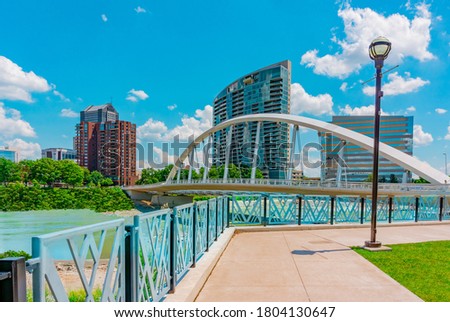 Downtown  buildings  and walkways line the river in Columbus, Ohio. A bridge crosses the river. 
