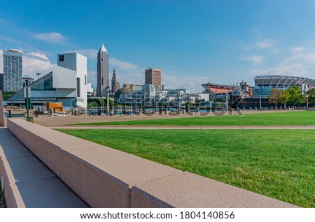 Downtown Cleveland Ohio with it's contemporary skyline includes a stadium and a freighter . Open boat slips await incoming vessels.