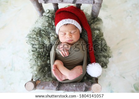 Sleeper newborn baby in a Christmas Santa cap, two week old. 