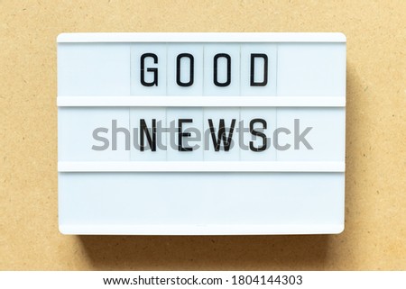 Lightbox with word good news on wood background