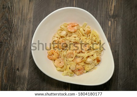 Top view of a bowl with Alfredo fettuccine pasta with shrimp and scallops.