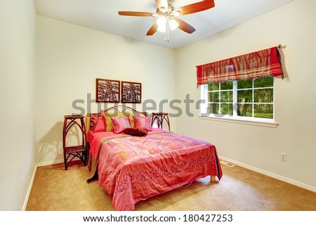Ivory wall bedroom with carpet floor and white french window. Furnished with wicker stands and bed