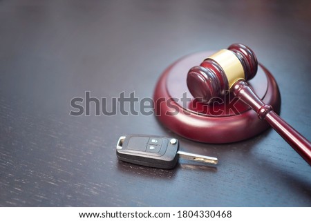 Driver license revocation concept next to the judge hammer. Traffic violation concept by car next to judge hammer. Revocable trust on a dark desk. Royalty-Free Stock Photo #1804330468