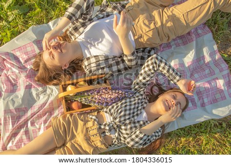 Picnic in nature Girls lie on the grass, laughing