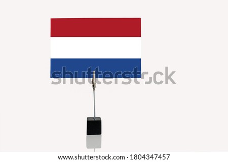 Dutch Republic miniature flag in cube base in photograph holder on a white background