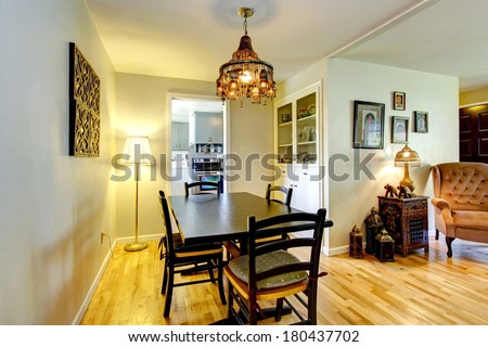 Bright dining area with hardwood floor, black table set and build-in cabinet