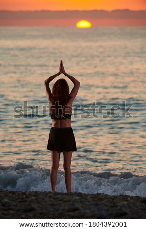 Yoga and meditation on calm beach at sunrise, Young fit women, Woman doing yoga outdoors at sunrise on the beach - Woman meditating at morning time