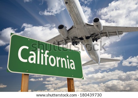 California Green Road Sign and Airplane Above with Dramatic Blue Sky and Clouds.