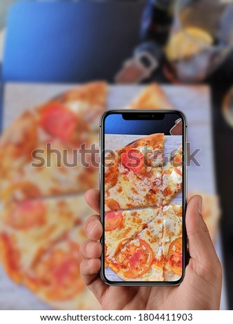 
Boy taking photo with his mobile of food in a restaurant