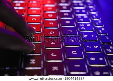 Close up of laptop keyboard colorful neon illumination, backlit keyboard. Selective focus on Y.