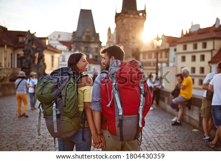 young happy man and woman in love traveling,having a good time on street at sunset.