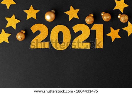 Concept of the year 2021. Golden stars with 2021 numbers on paper background