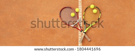 Tennis racquets with tennis balls on clay court Royalty-Free Stock Photo #1804441696