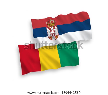 National vector fabric wave flags of Guinea and Serbia isolated on white background. 1 to 2 proportion.