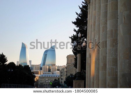The Old City classic buildings in Baku with modern Flame Towers in the background on sunset. Baku Azerbaijan