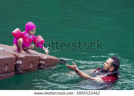 Asian family swimming at the Kenyir Lake, Malaysia.