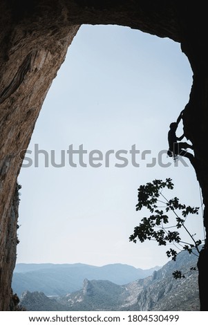 Climbing a cave with mountain views in the background