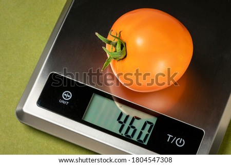 fresh yellow omato on a digital nutrition diet scale, healthy eating concept Royalty-Free Stock Photo #1804547308
