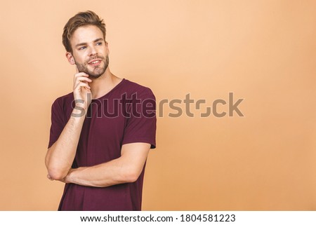 Portrait of a handsome man in glasses against beige background with copy space. Smiling guy in casual standing in casual isolated. Successful hispanic man looking at camera.