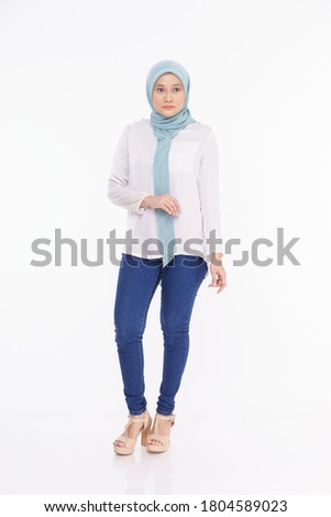 Fashionable young woman in long sleeves white shirt and jeans with hijab isolated over white background. Stylish Muslim female hijab fashion lifestyle  concept.