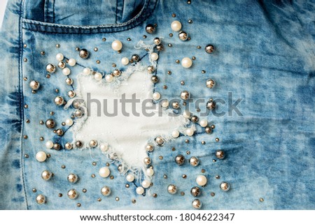 Jeans background clothing. Denim fabric closeup. Textures of clothing made of fabric with fashionable embroidery of pearl beads. Copy space for text. Fashionable style. Royalty-Free Stock Photo #1804622347