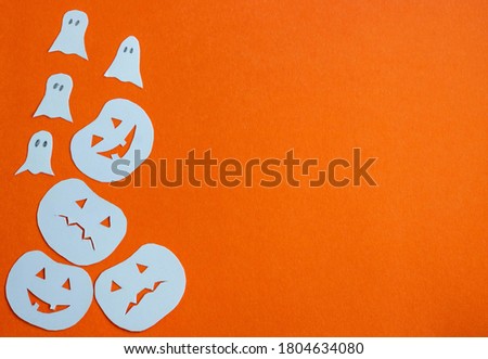 The concept of the Halloween holiday. Halloween decorations, pumpkins, ghosts on an orange background. Flat bed, top view text space