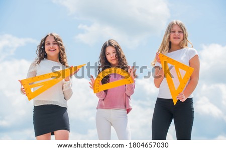 Education concept. School students learning geometry. Girls with triangle ruler. Smart friends. School friendship. Study group can help solidify and clarify material. Study together. Clever kids.