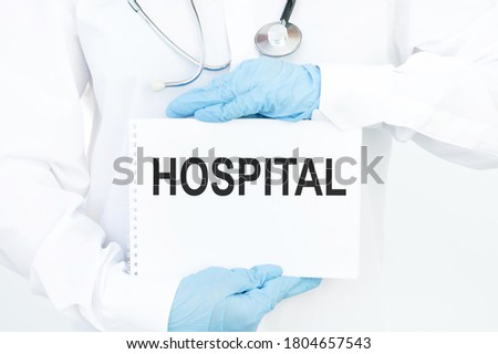 card with the text HOSPITAL in the hands of a doctor