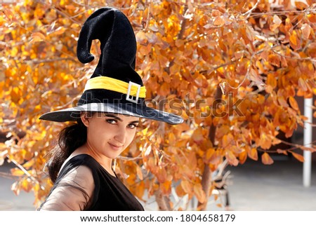 Halloween portrait of a young middle-eastern woman dressed in witch costume