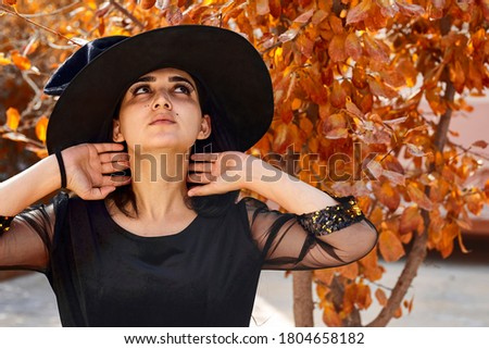 Halloween portrait of a young middle-eastern woman dressed in witch costume