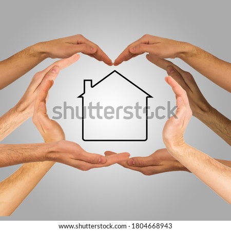 Hands make heart shape on a gray background